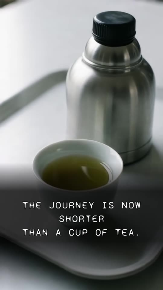 A cup of green tea and a flask on a train tray, captioned: the journey is now shorter than a cup of tea. From vignette 058.
